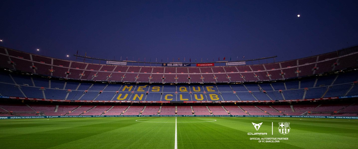 Empty stadium stands of the Camp Nou with the message More than a club in Catalonian.