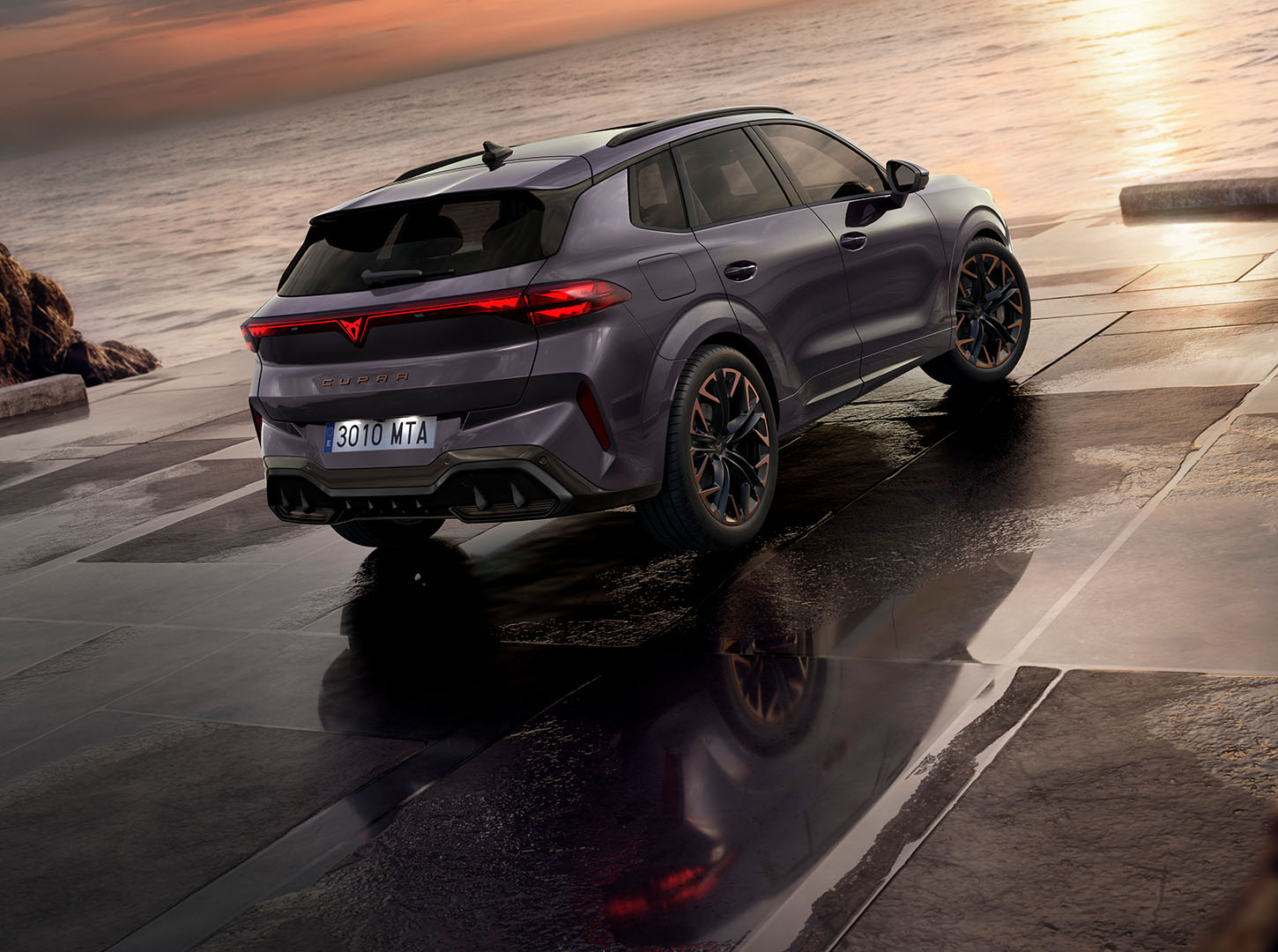 Rear-view of the CUPRA Terramar parked in a concrete surface facing the sea.