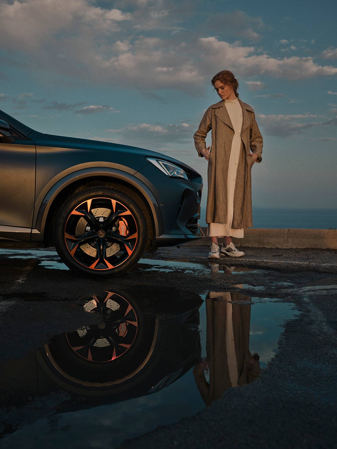 woman-standing-next-to-the new CUPRA Formentor  with brembo brakes and alloy wheels in copper