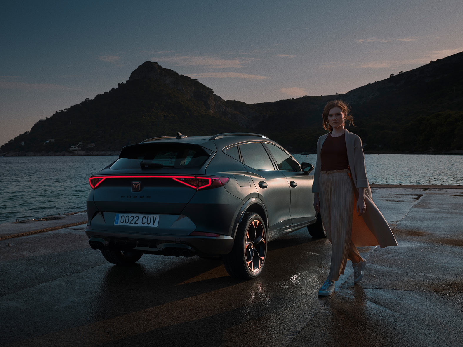 woman standing next to the new cupra formentor suv with full led lights