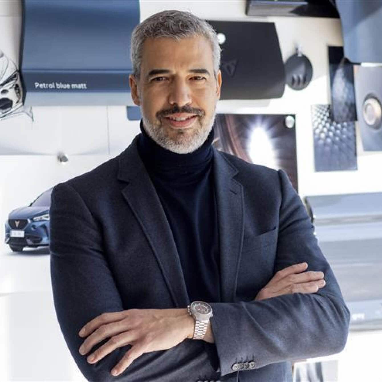 Jorge Diaz, facing his back into a wall covered with cupra designs, including fabrics and sketches.