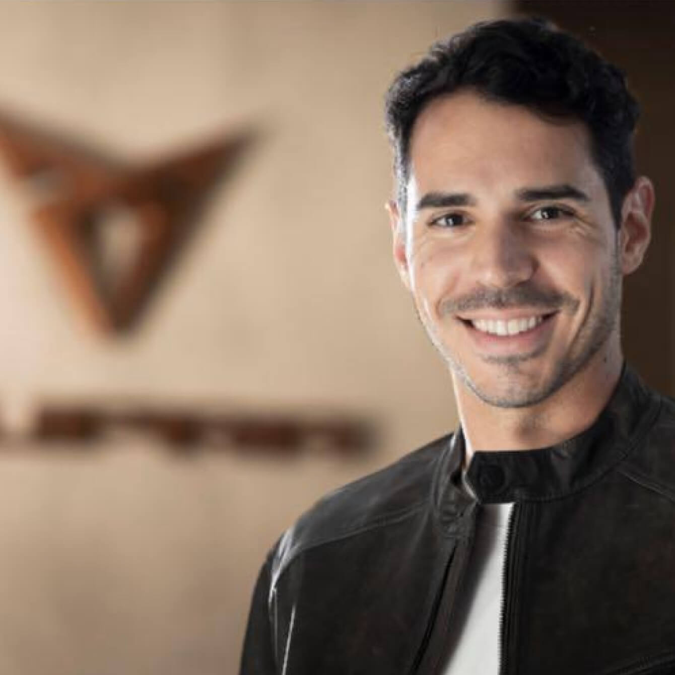 Miguel Diez, facing the camera with a background with the logo of CUPRA.